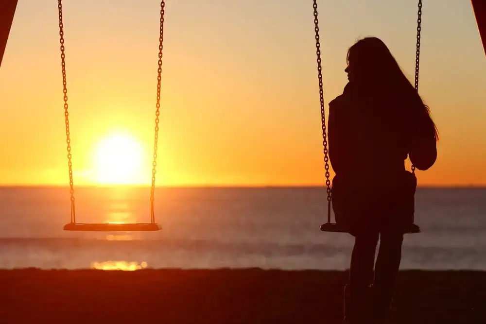 garota em um balanço ao pôr do sol