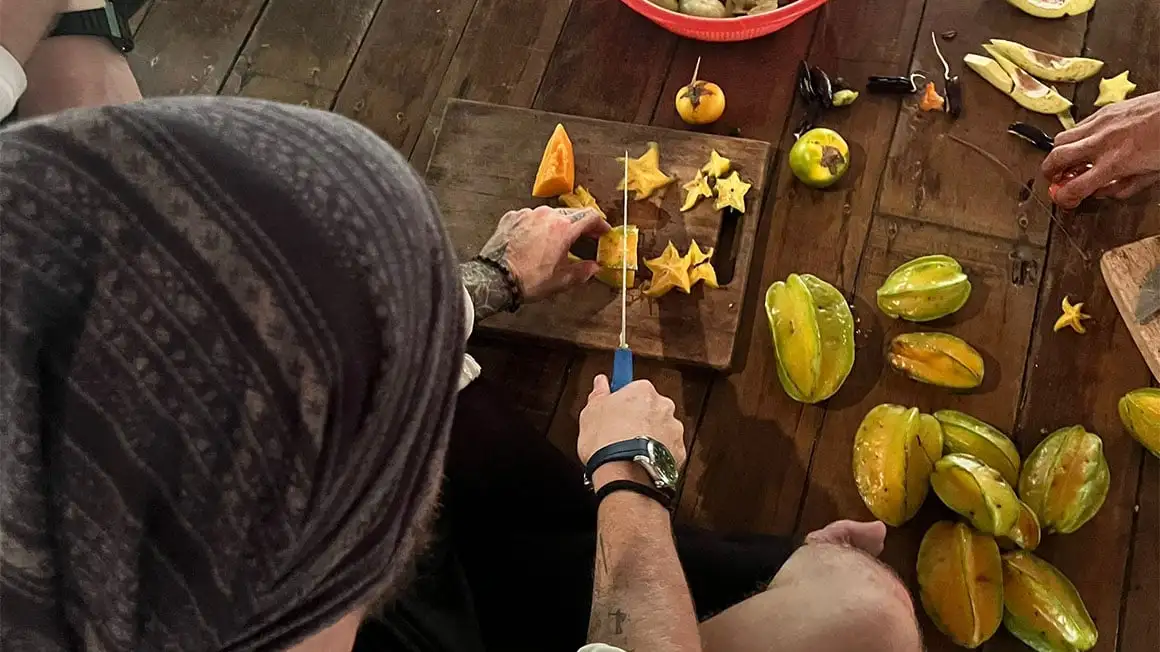 Couper des fruits de calambola sur une planche à découper en bois.