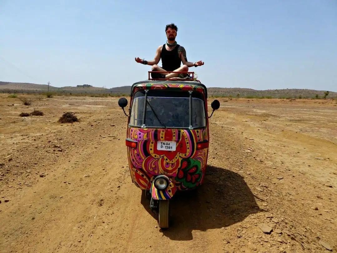 Sera assis dans une pose de yoga zen au sommet d'un pousse-pousse/tuk tuk coloré en Inde