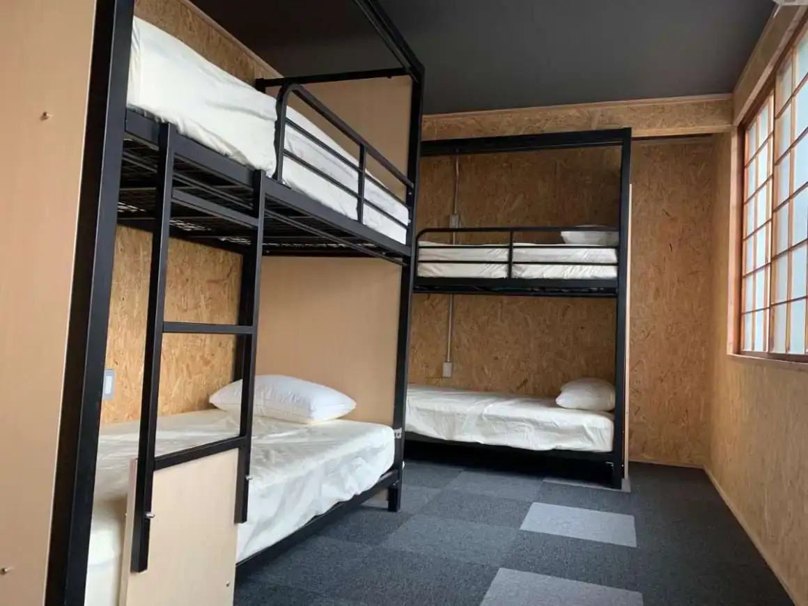 Kamar sederhana dengan tempat tidur susun yang terletak di depan jendela besar di Unstapped Hostel
