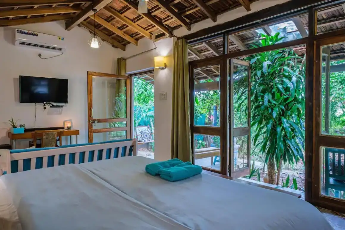 une plage tropicale à Goa en Inde remplie de baigneurs et de palmiers verts
