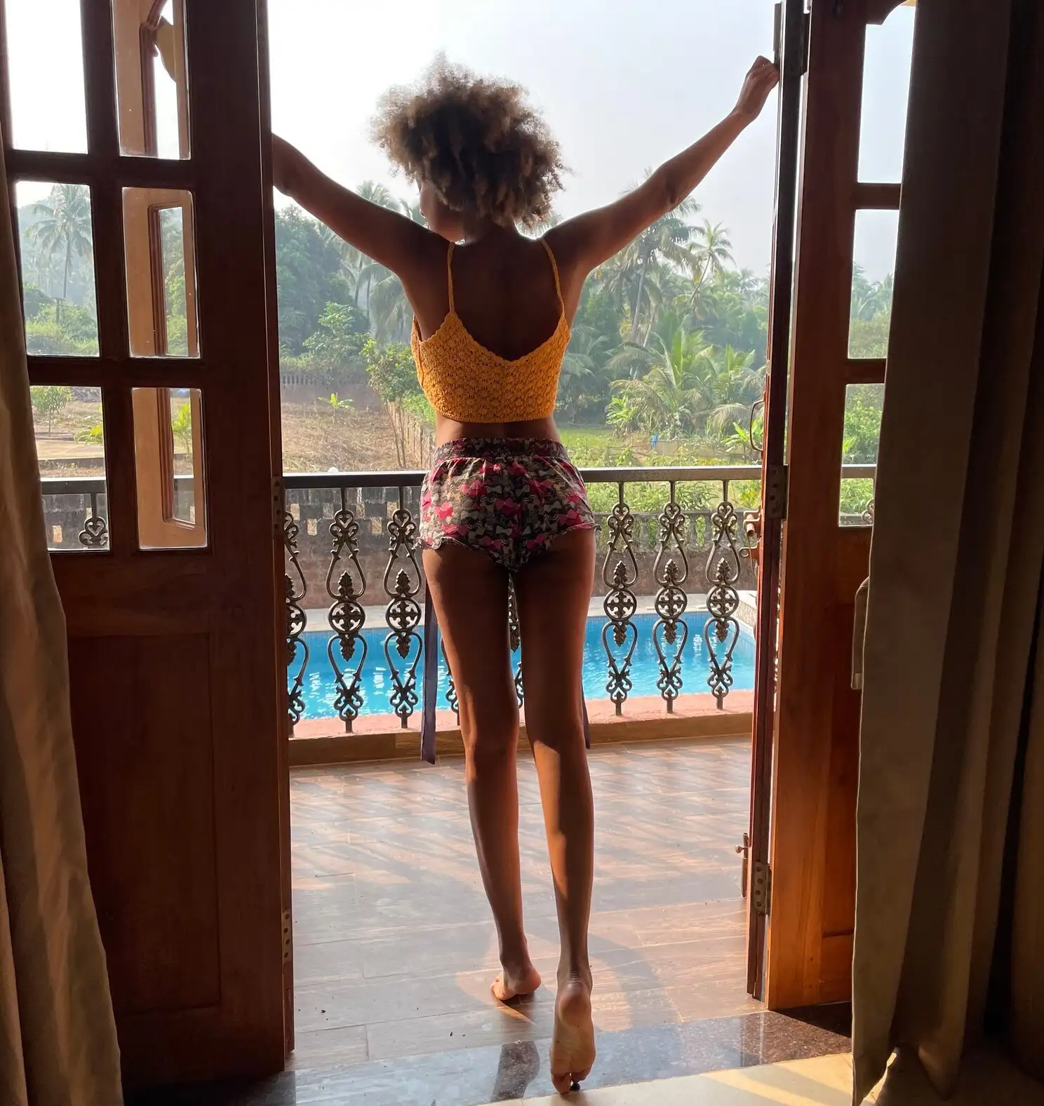fille debout donnant sur un balcon avec une piscine sous Whuile séjournant à Goa