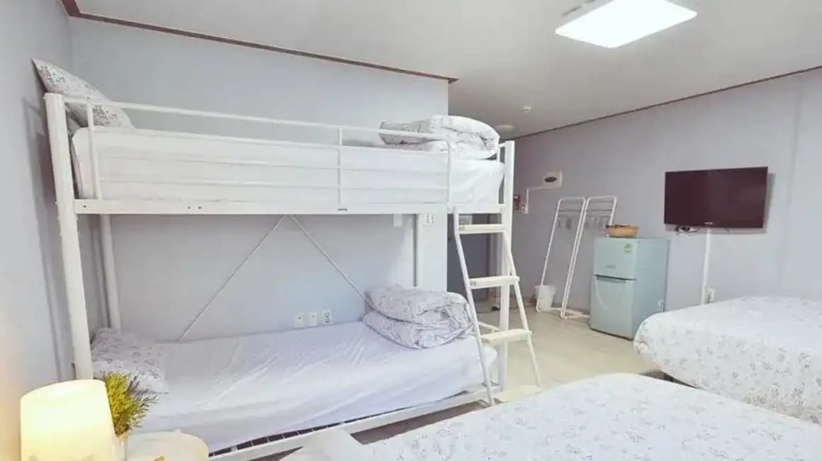 Kerrossängyt valkoisessa huoneessa Myeongdong Rooftop Hostelissa