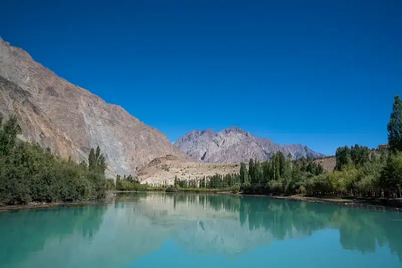 tons de azul do lago Phander enquanto viajava de mochila às costas no Paquistão