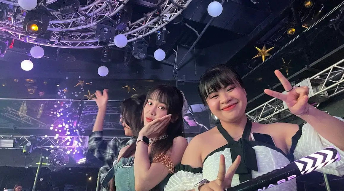 Deux jeunes filles japonaises souriant pour une photo dans un club de Tokyo.