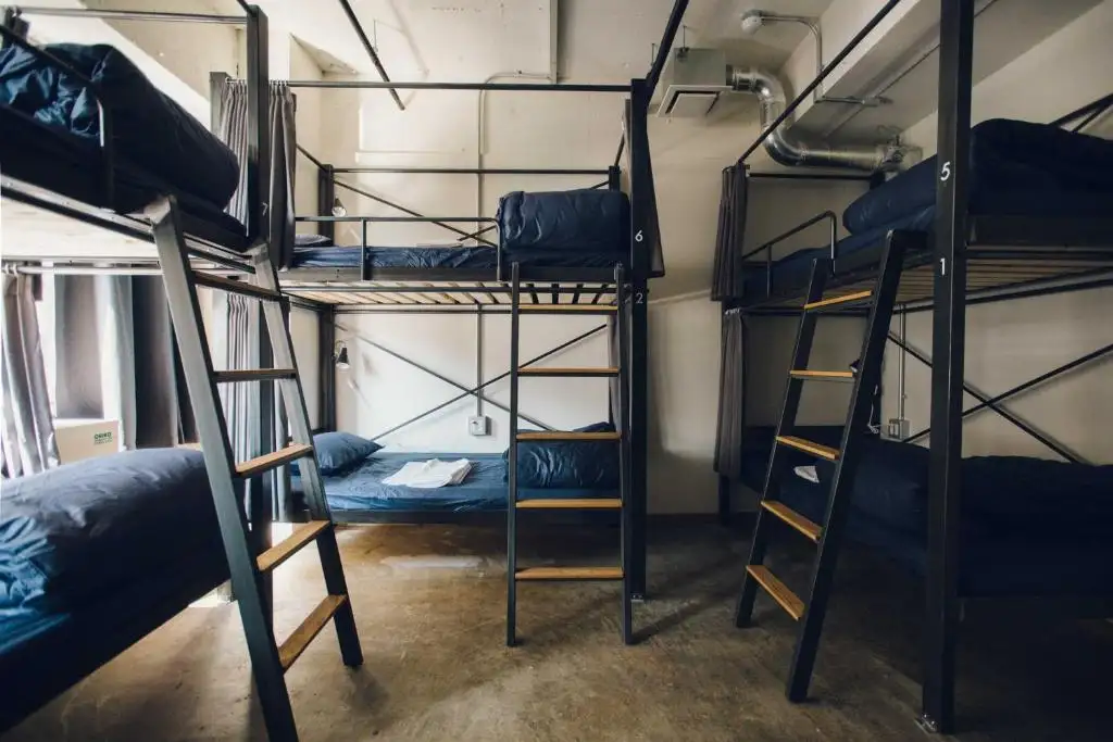 Balta dviaukštė lova su darbo vieta ir dideliu langu Nui. HOSTEL & BAR LOUNGE