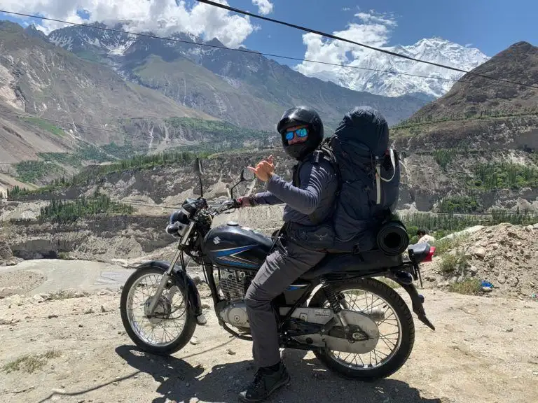 estarà assegut en una moto amb motxilla i casc a la vall de Hunza