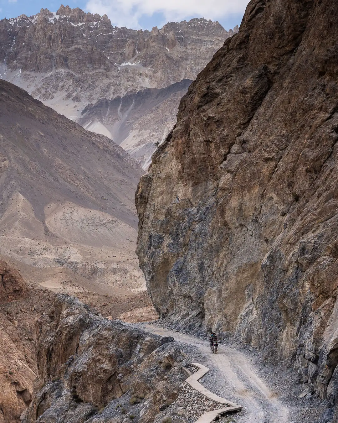 persona que va amb una moto petita en una carretera de terra a l'extrem nord del Pakistan