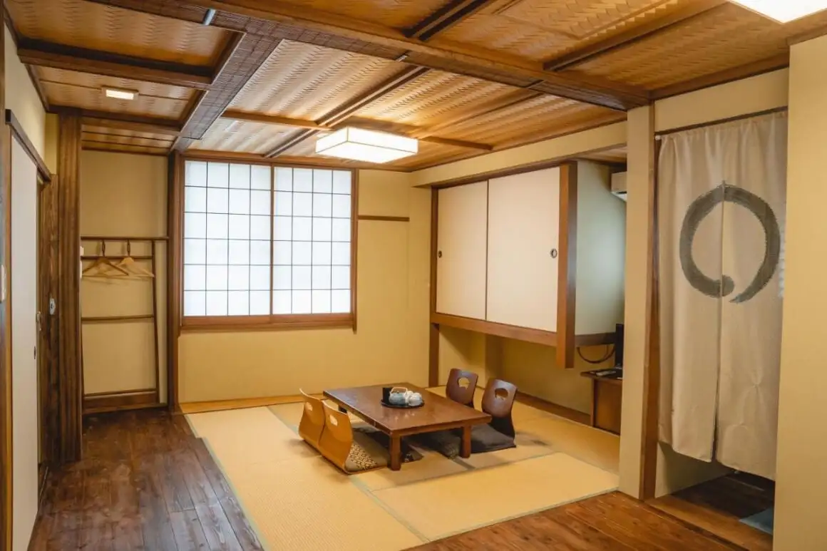 瓢濤の旅館もとなごの木のテーブルと椅子4脚のあるリビングルーム