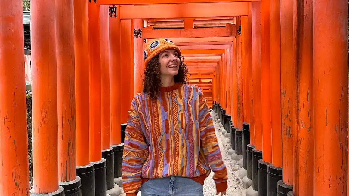 Jente som går gjennom de vandrende Torii-portstiene i Kyoto, Japan.