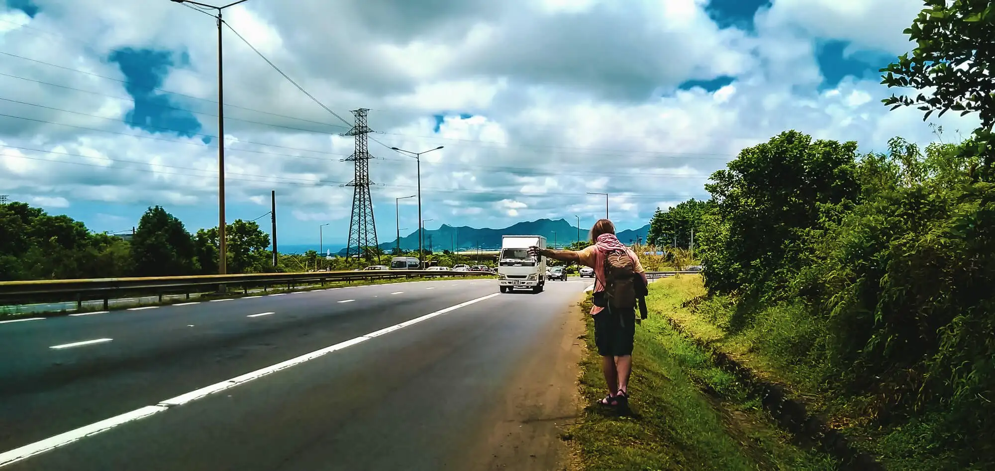 Un homme fait du stop à Maurice avec un ami voyageur de longue date