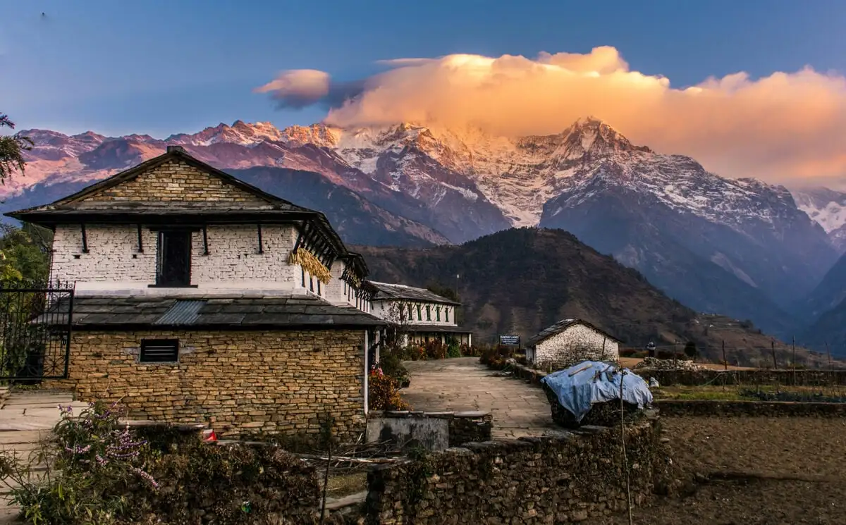 Famille d'accueil rurale avec des montagnes derrière elle au Népal