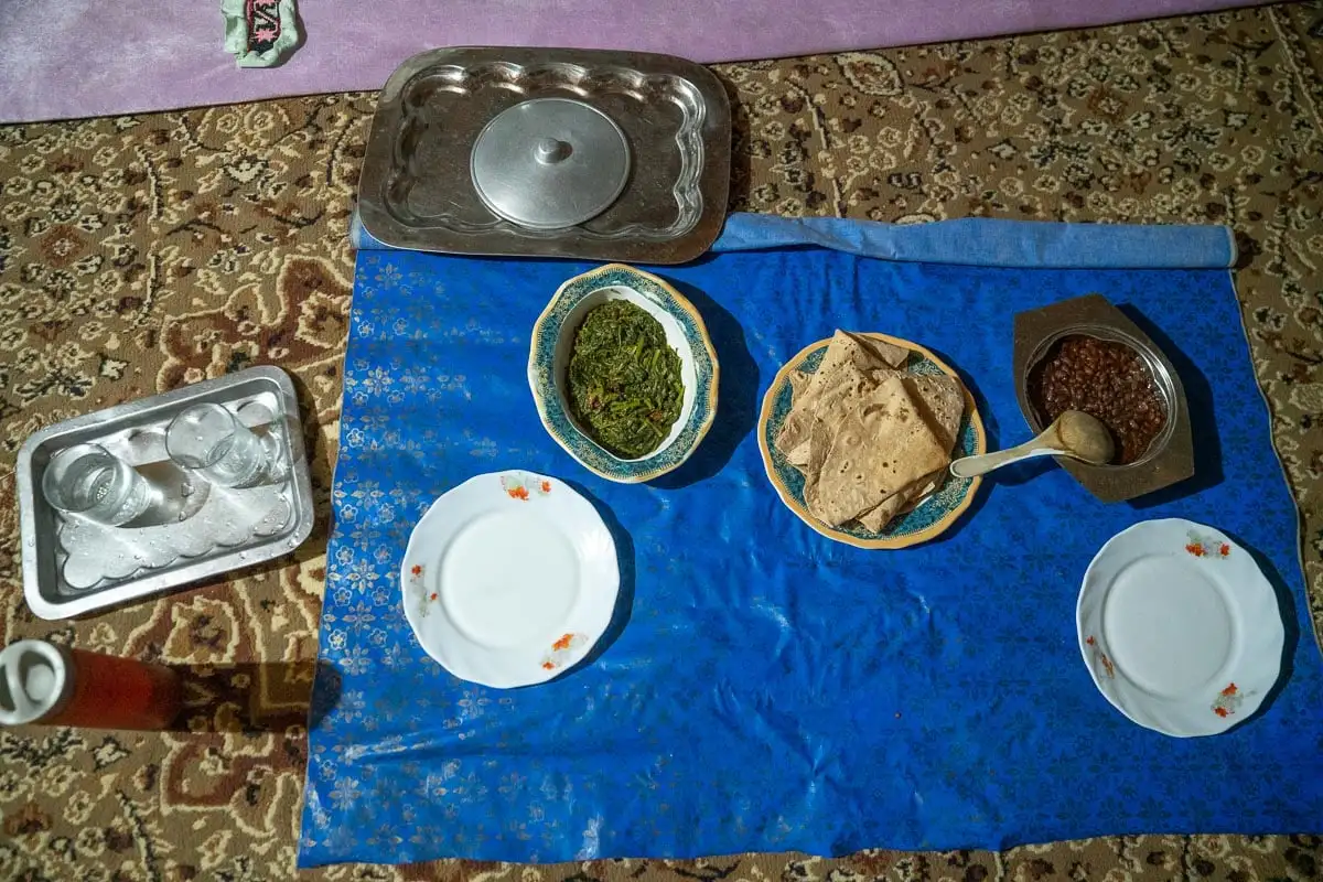 un repas étalé sur un tapis bleu dans une famille d'accueil
