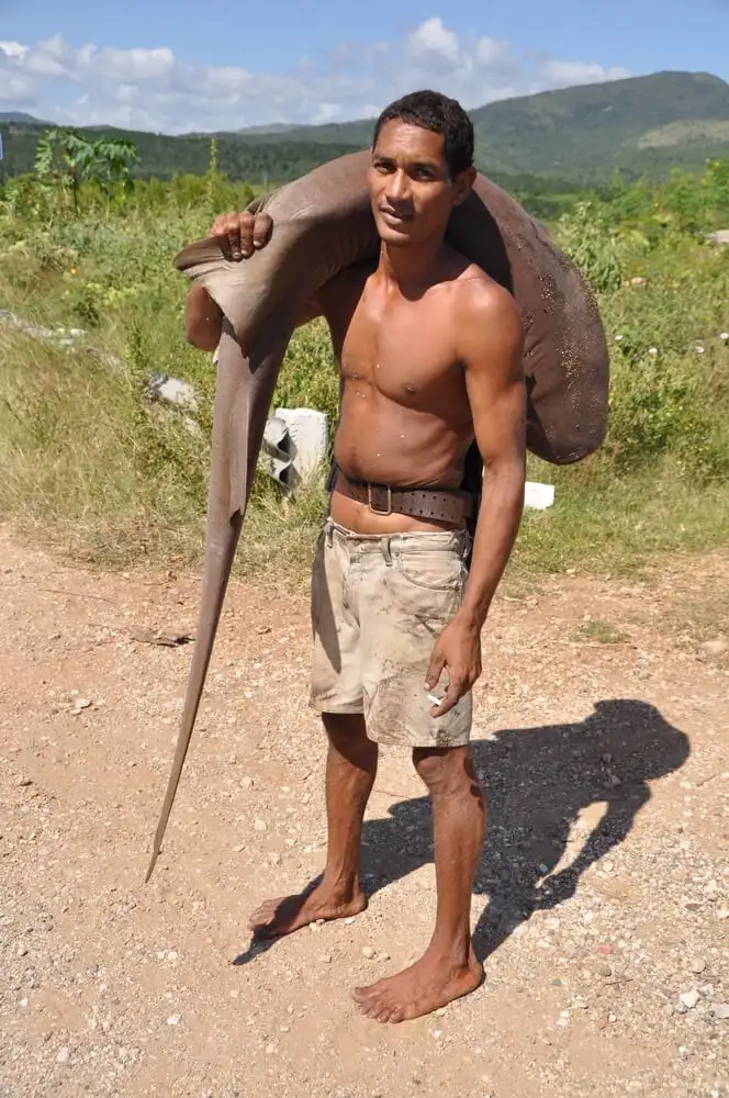 फ्लोरिडा में एक आदमी अपने कंधे पर मछली ले जाता है