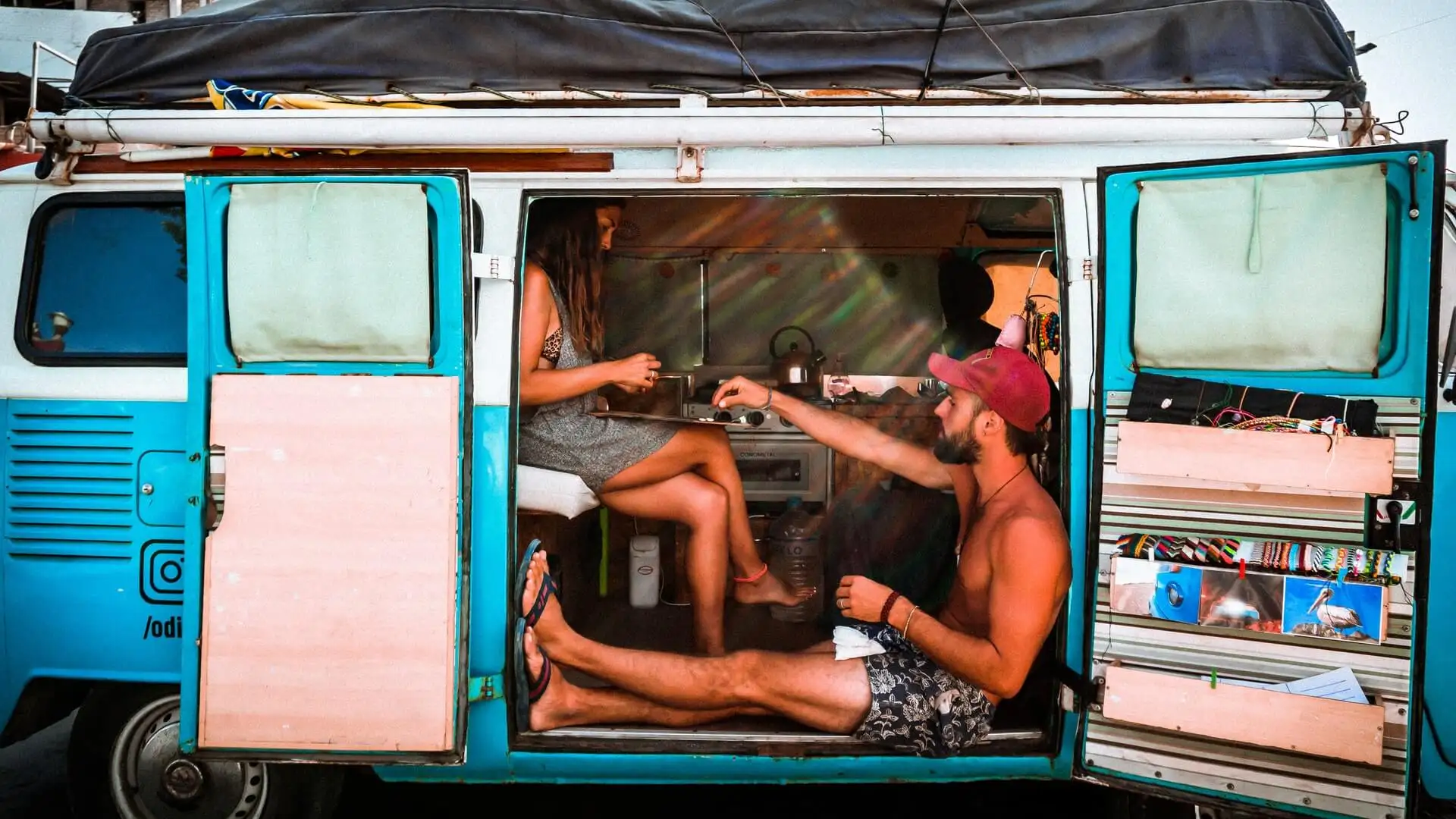 casal assistindo o nascer do sol fora de sua barraca enquanto acampava