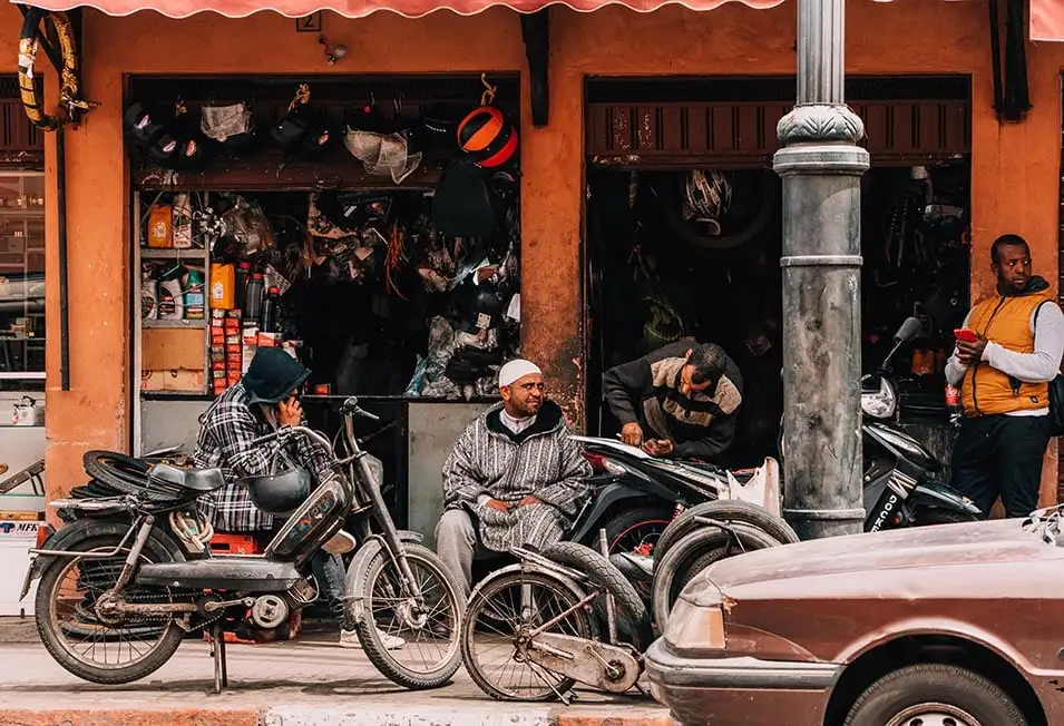 Homens do lado de fora de uma parada mecânica em Marrakech, Marrocos.