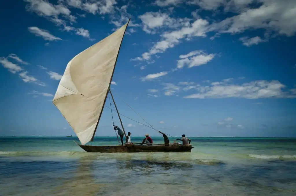 quatro homens navegando em um dhow (tipo de veleiro)