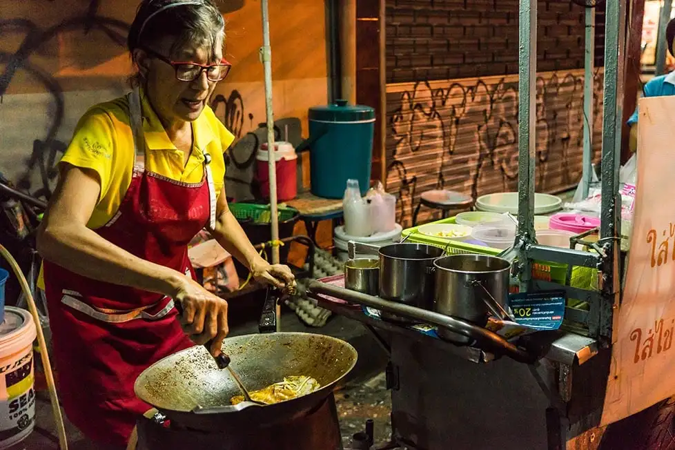 Uma mulher cozinhando Pad Thai na rua em Bangkok.