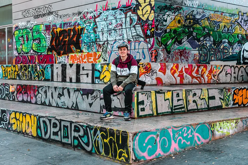 Uma pessoa andando em alguns degraus em Barcelona cercada por grafites