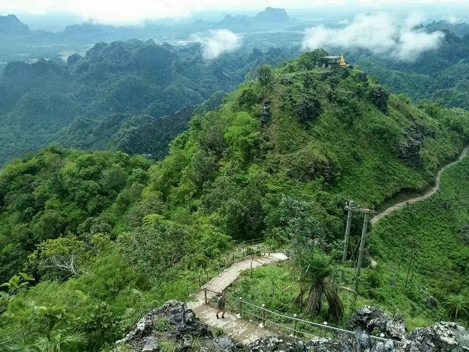 Um pequeno templo dourado em uma grande selva de montanhas em Mianmar.