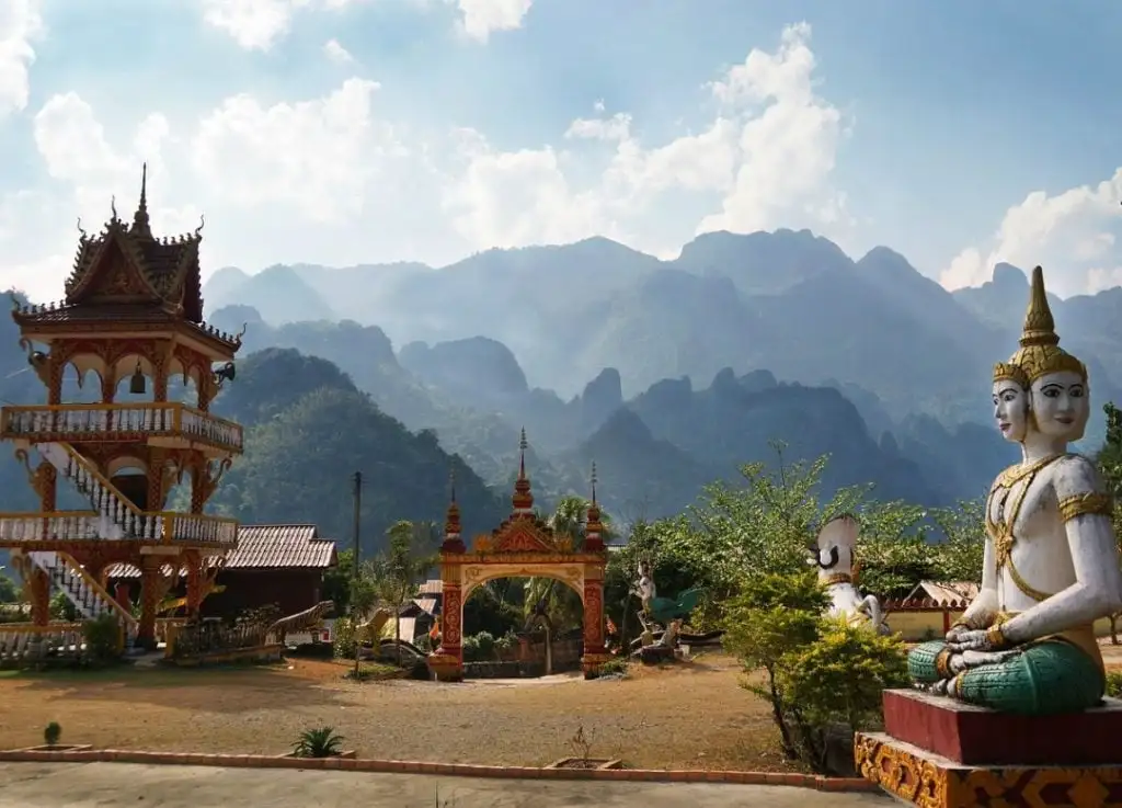 Um templo e uma estátua nas montanhas enquanto viajava de mochila às costas no Laos