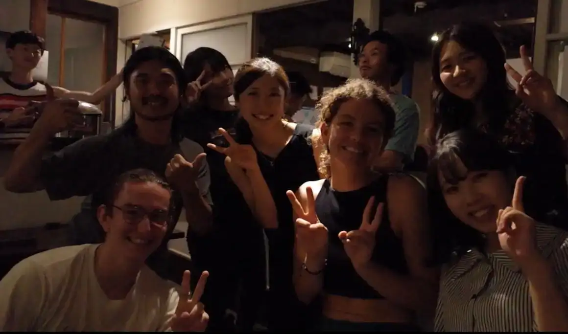 Un groupe d'amis sourit pour une photo dans une auberge de jeunesse à Nagano, au Japon.