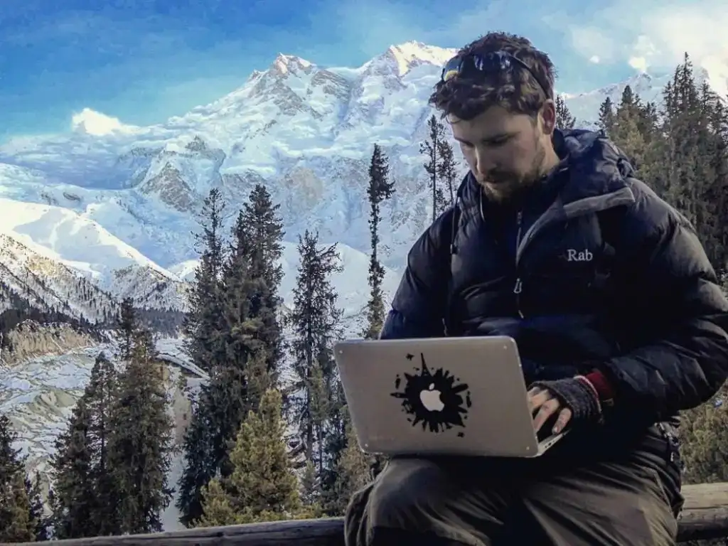 Hatton travaillera sur l'ordinateur portable avec fond de montagne