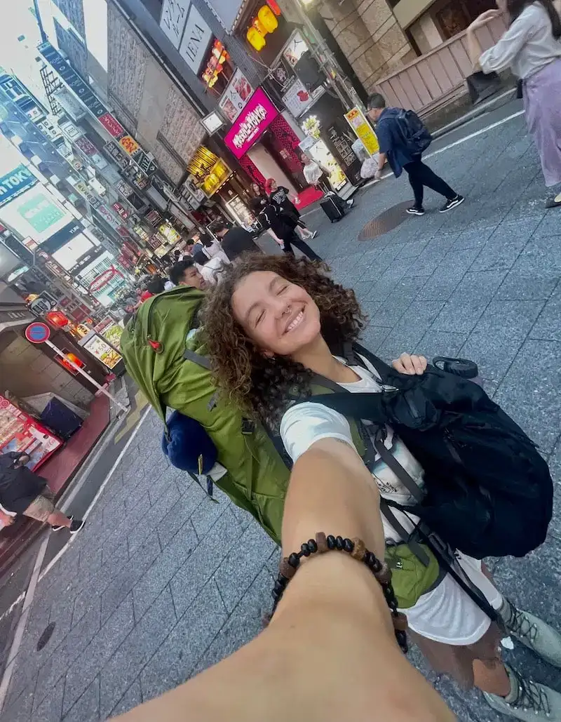 La fille sourit alors qu'elle parcourt les rues de Tokyo au Japon.