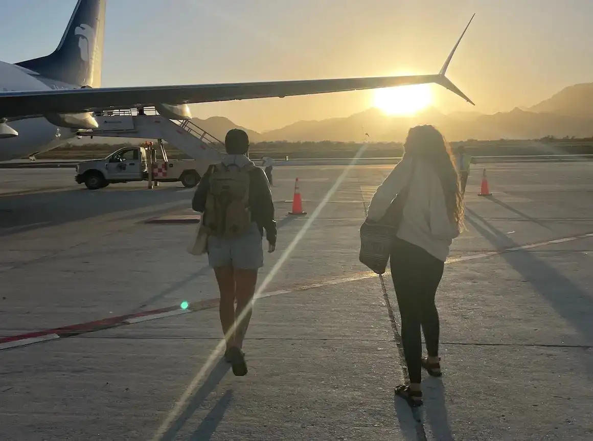 Deux filles marchant vers un avion au coucher du soleil au Mexique