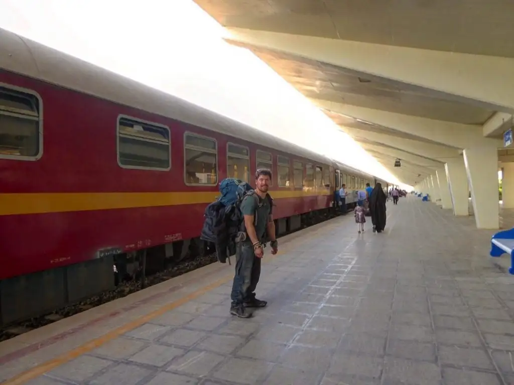 mochileiro em pé em uma plataforma em uma estação de trem no Irã