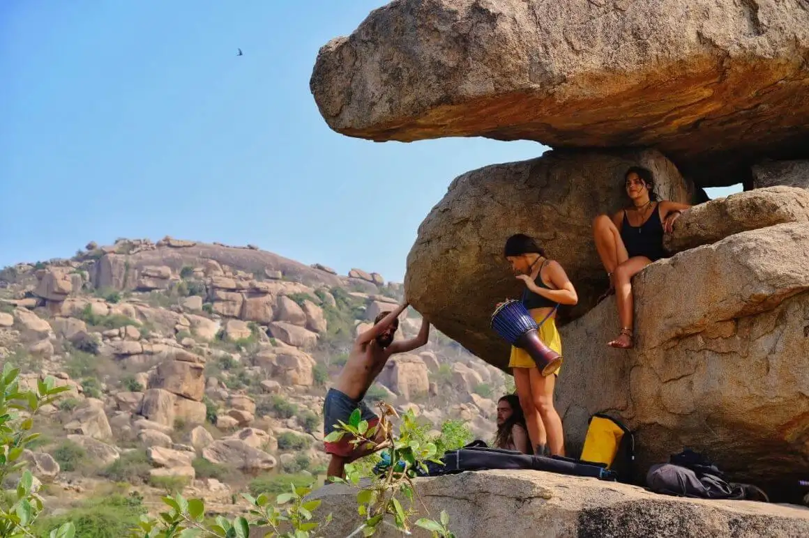 amigos ficam tocando música nas pedras em Hampi, Índia