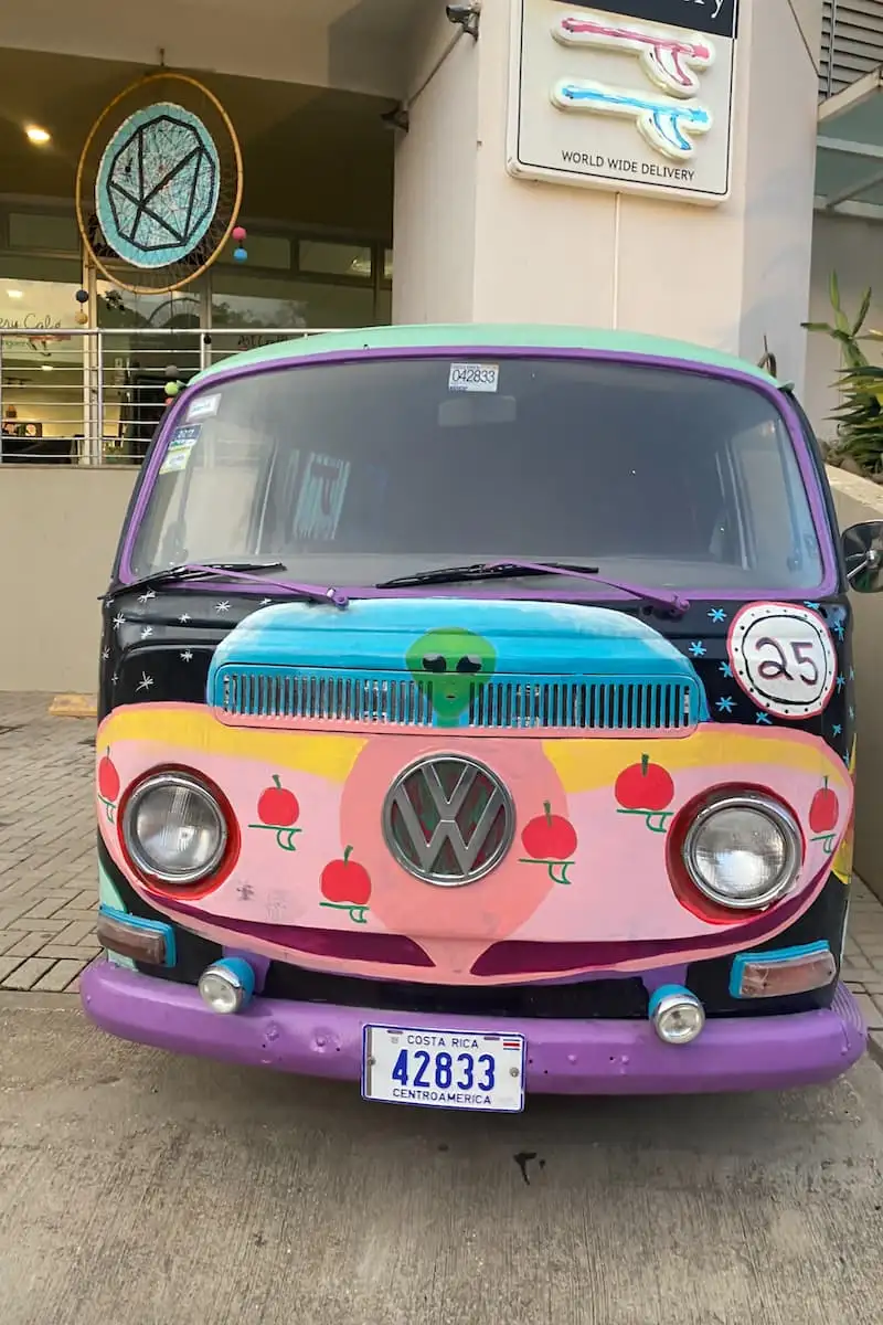 Un camping-car couvert de graffitis sympas dans un camping bordé de palmiers