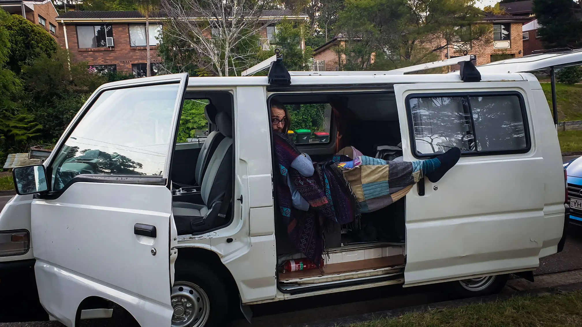 Un routard nouveau dans la vie en van posant à l'intérieur de son nouveau camping-car