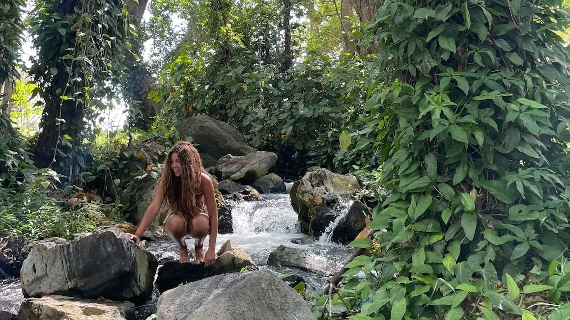 Fille assise au bord d'un ruisseau dans la jungle d'Ometepe, Nicaragua