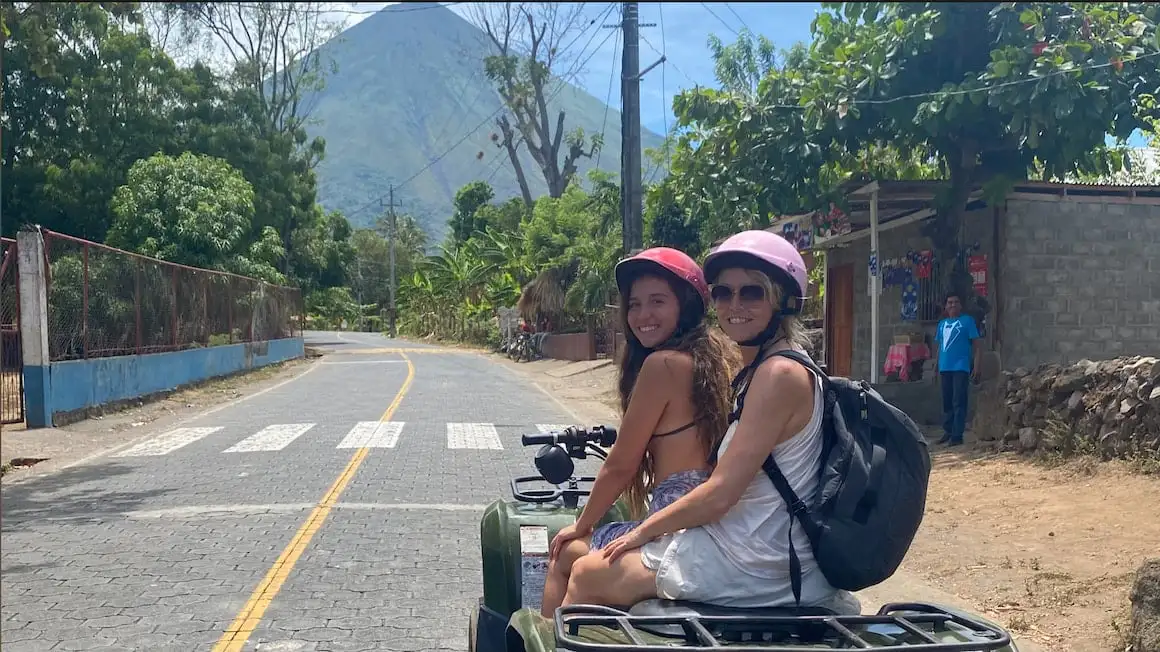 deux filles sur un VTT explorant Ometepe, Nicaragua avec vue sur un volcan
