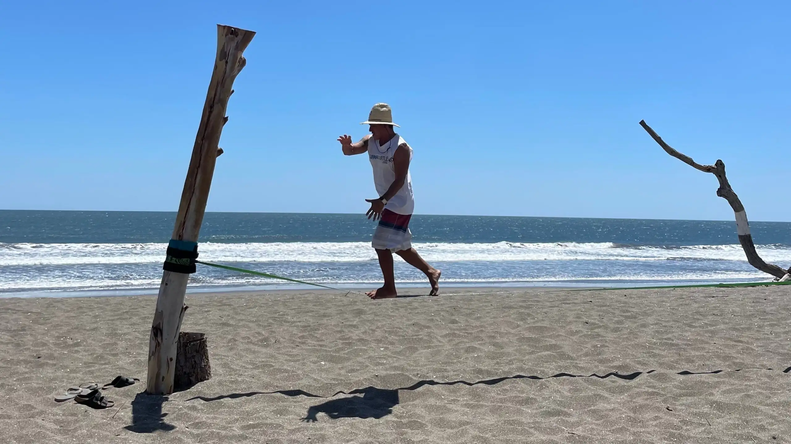 une fille souriante tenant une planche de surf sur le point d'aller dans l'océan