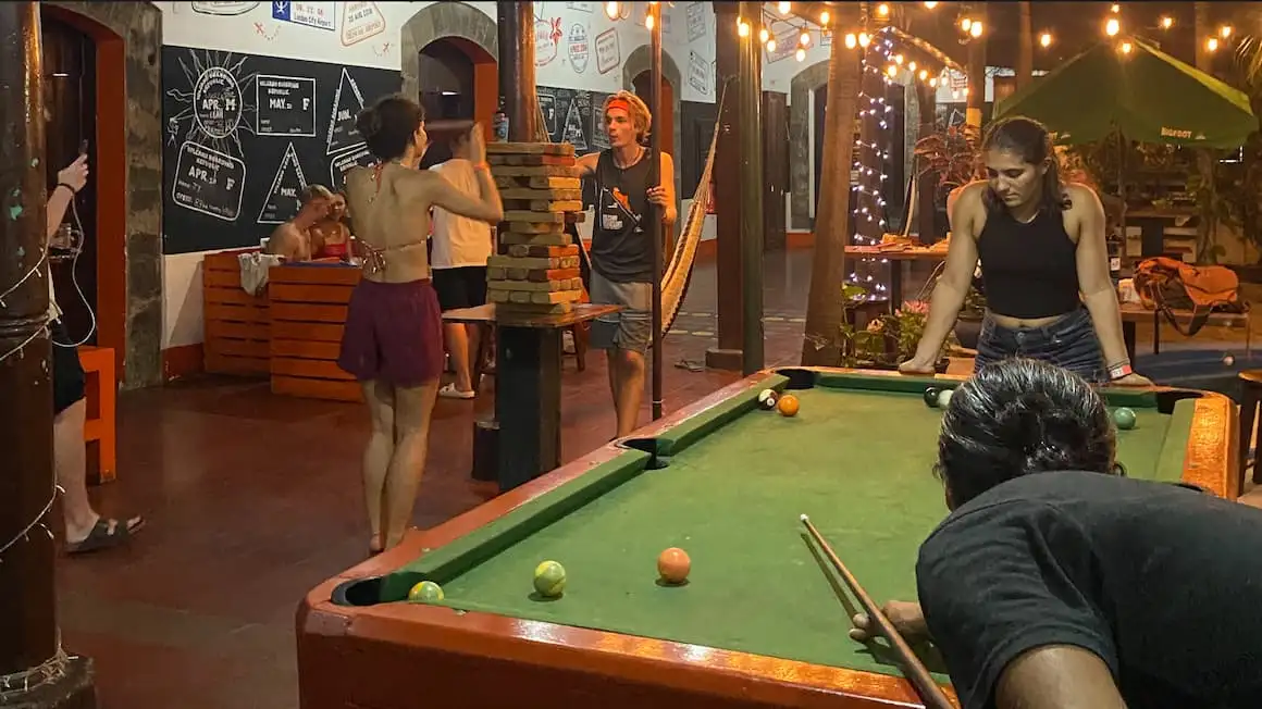 un groupe d'amis jouant au jenga et au billard sur une table de billard dans une auberge au Nicaragua