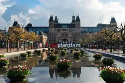 Barco de canal passando por baixo de uma ponte em Amsterdã em um dia ensolarado