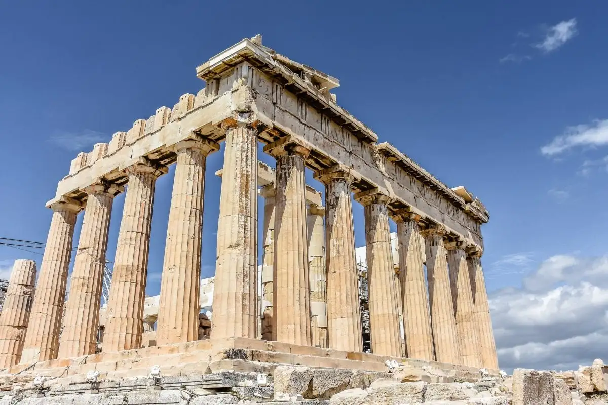 grand groupe d'amis sur un toit à Athènes la nuit avec vue sur l'acropole éclairée en arrière-plan