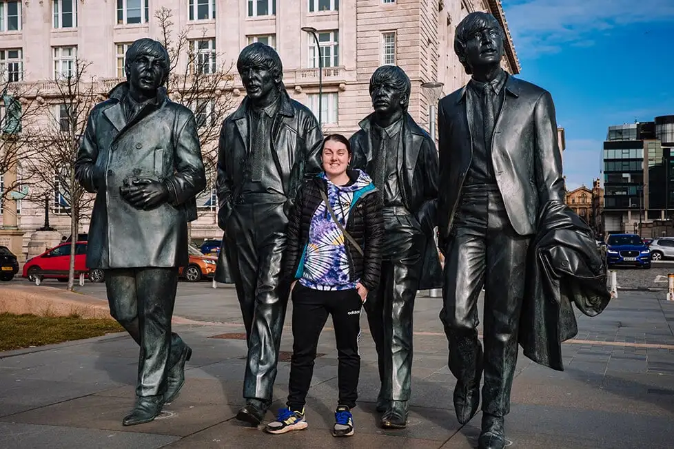 Uma pessoa estava em frente a uma estátua dos Beatles em Liverpool