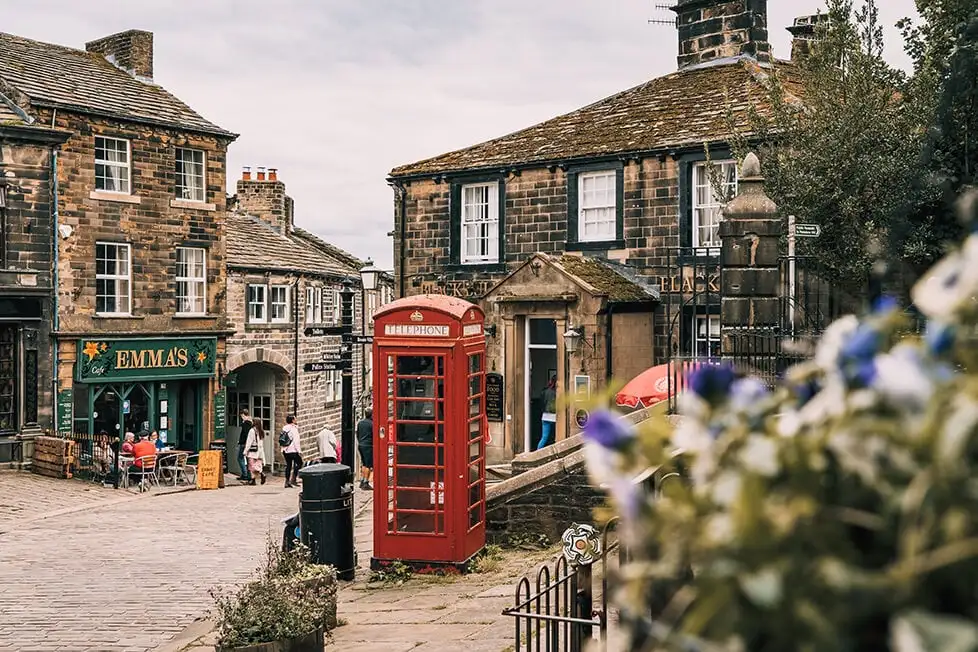 Uma cabine telefônica vermelha em uma rua pitoresca de uma vila inglesa