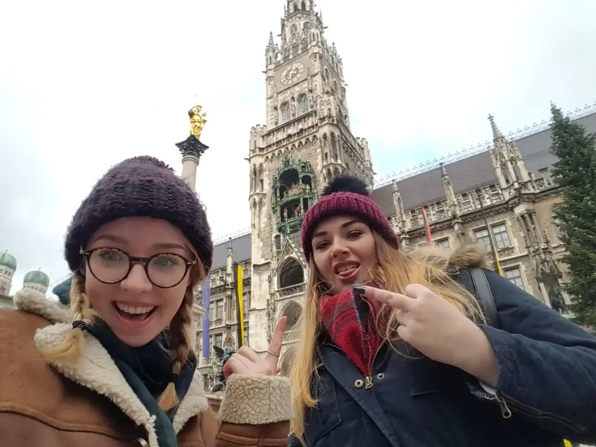 2 femmes posant devant la caméra dans des vêtements chauds devant le Rathaus de Munich