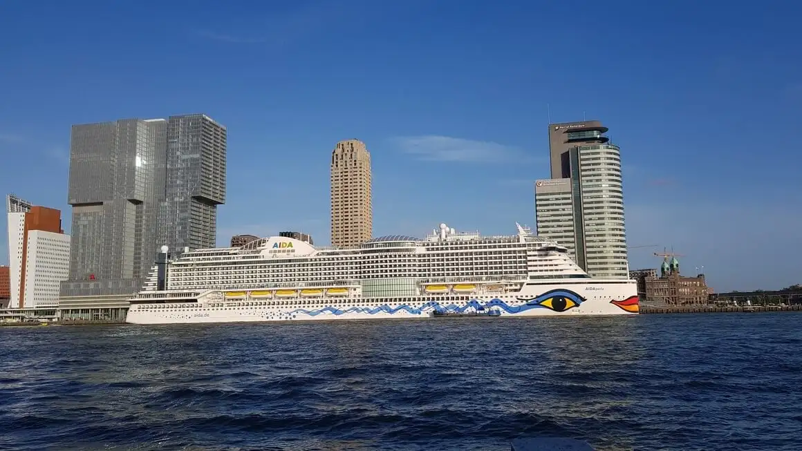 Grand bateau de croisière se fondant dans l'horizon du port de Rotterdam.