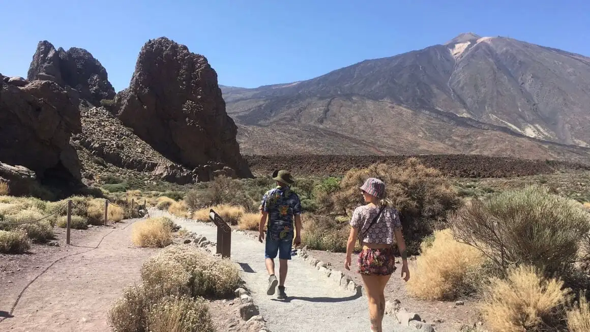 Dwie osoby idą w kierunku góry El Teide na Teneryfie w słoneczny dzień