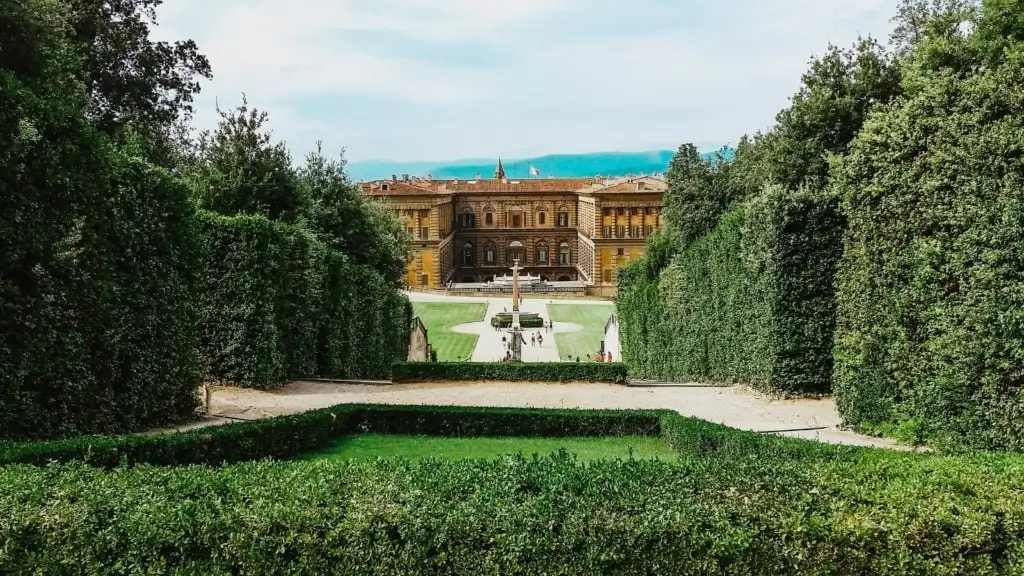 exuberantes jardins verdes que levam a um antigo edifício amarelo em Florença, Itália
