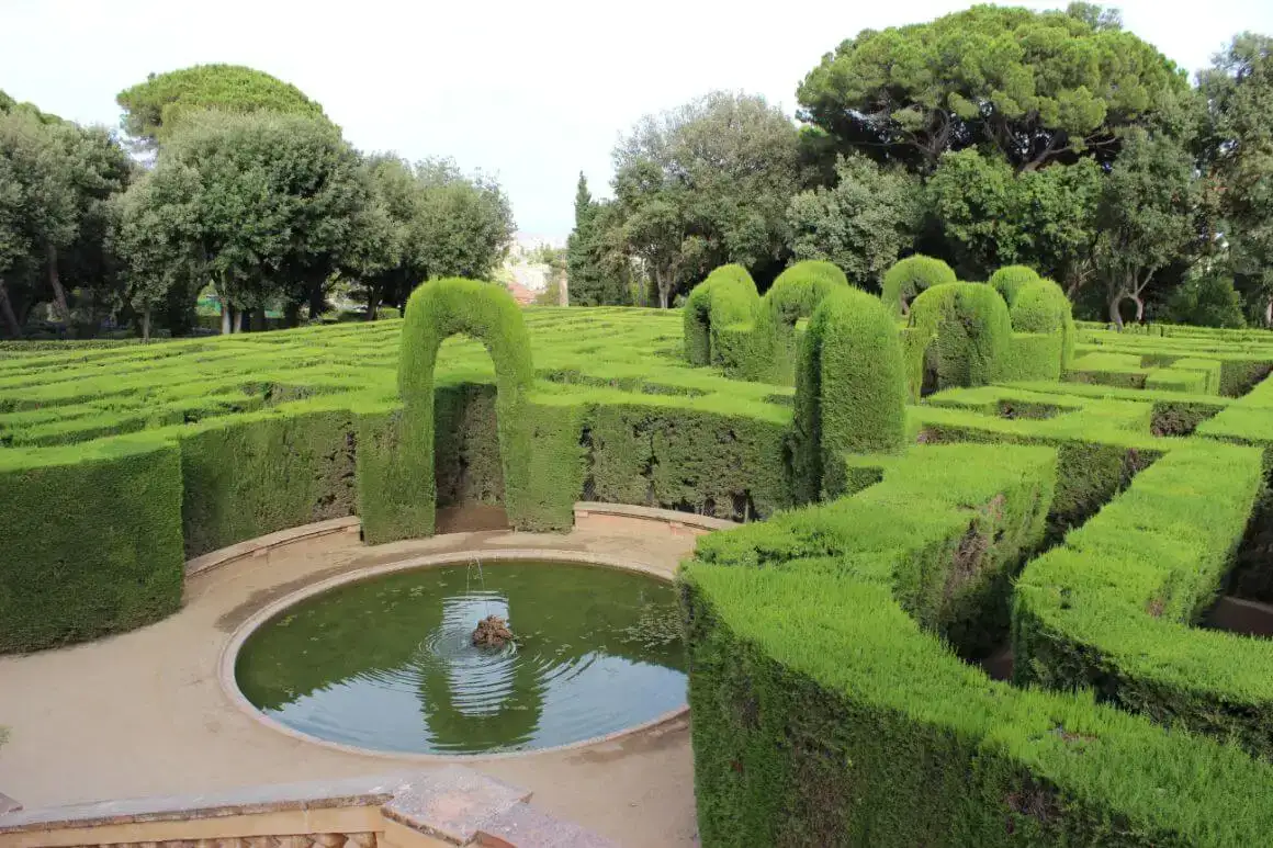 Un bâtiment avec des arches donnant sur une grande cour arborée à Barcelone