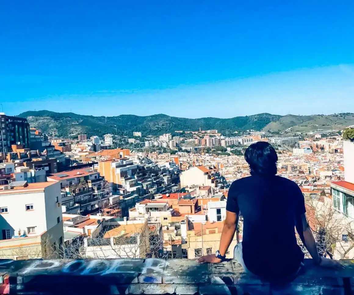 Une personne admirant la vue depuis la colline Turó de la Rovira, Barcelone
