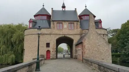 Edifícios ornamentados e uma igreja numa praça em Bruges, Bélgica