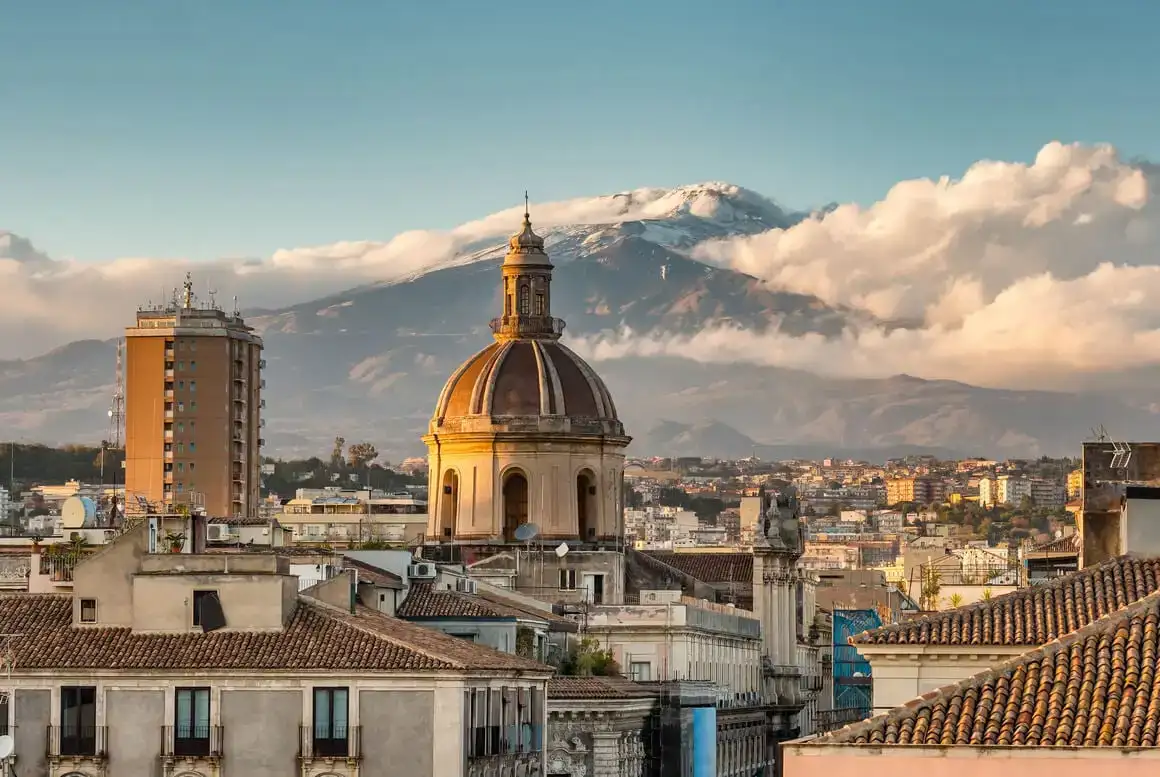 Sicilya, İtalya'da gün batımında Etna yanardağı manzaralı Catania şehir manzarası.