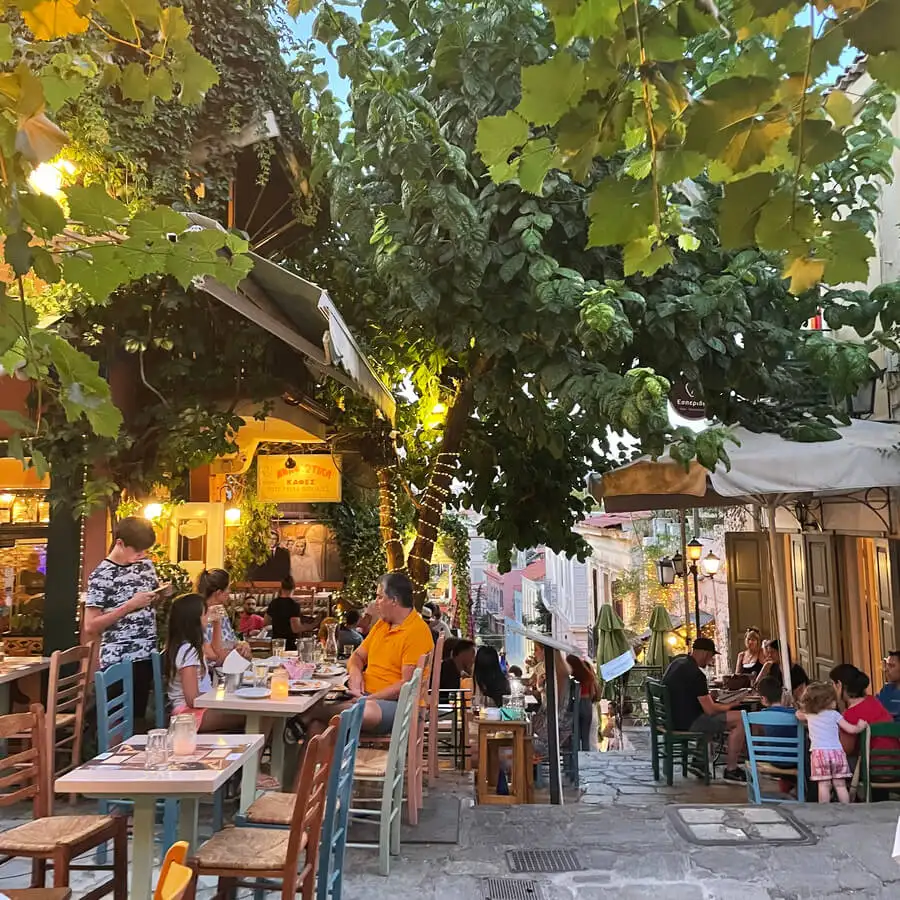 Mga kalye ng Plaka na puno ng mga restaurant, tao at mga puno